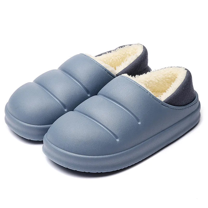 Pair of yellow waterproof EVA slippers with plush lining and a textured non-slip sole on a wooden floor.