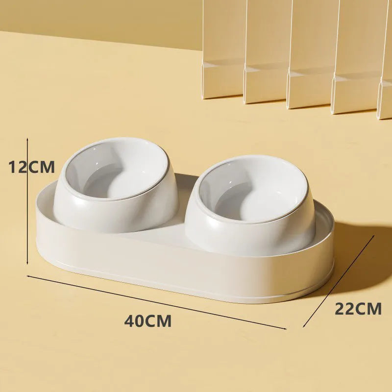White elevated pet feeder with two tilted bowls on a non-slip base, for cat and small dog food and water.