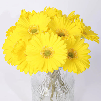 Silk artificial flower bouquet in a white polyurethane pot on a wooden table.