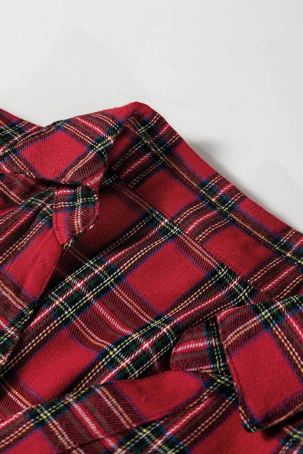 Red plaid mini dress with shirt collar, half buttons, long sleeves, and ruffle hem