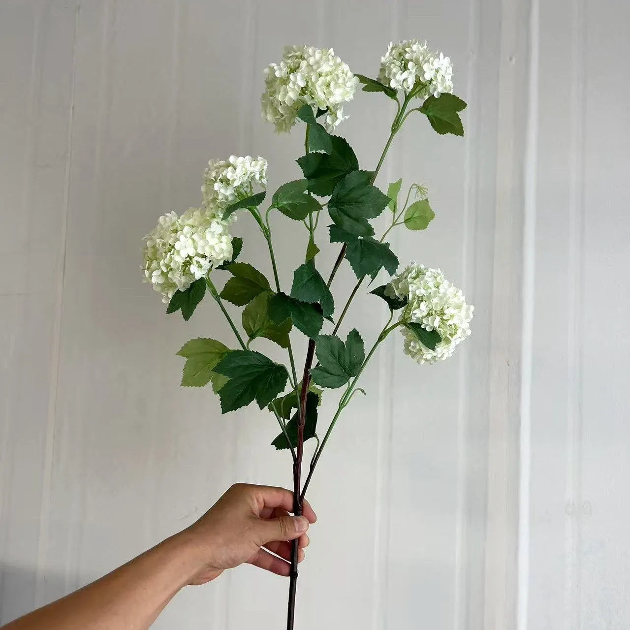 Artificial silk hydrangea flower on long stem branch in white or green colour