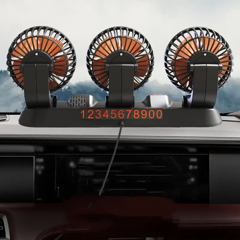 Three-head adjustable 12V car cooling fan with USB and cigarette lighter plugs on a dashboard.