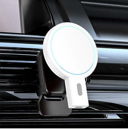 White and black magnetic wireless charging pad on a wooden table next to a smartphone.