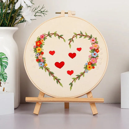 DIY Valentine's heart embroidery kit with cotton cloth and 20cm bamboo ring on a table.
