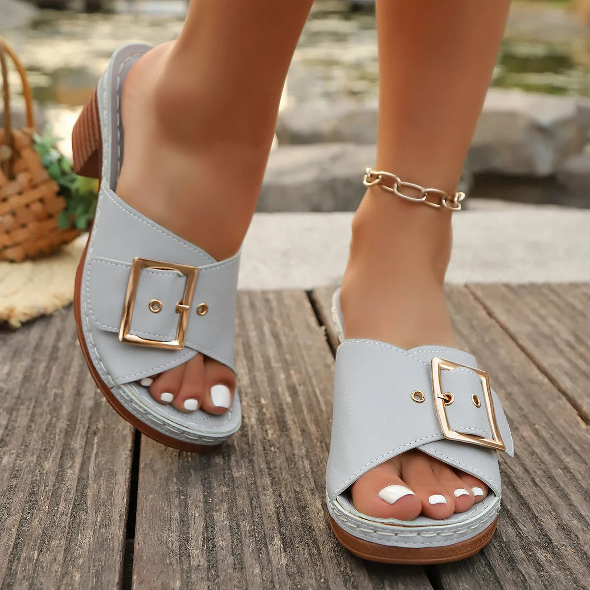 Women's black chunky heel slippers with a metal buckle and round toe, on a rubber sole
