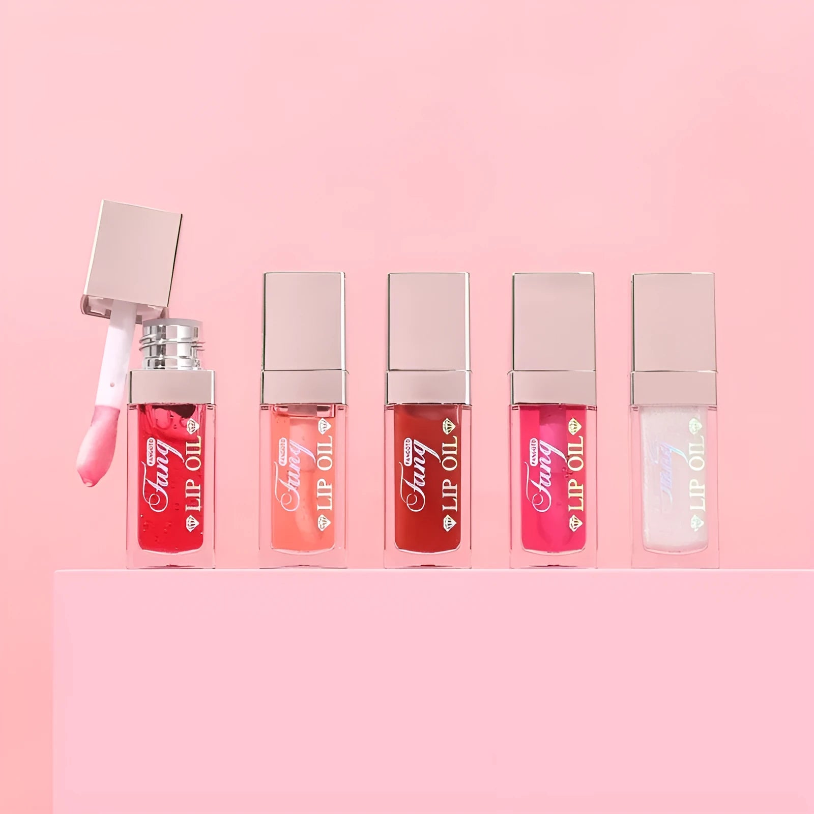 Set of five bright lip gloss tubes with lip essence oil applicators in shades Style001, 006, 007, 012, and 015.