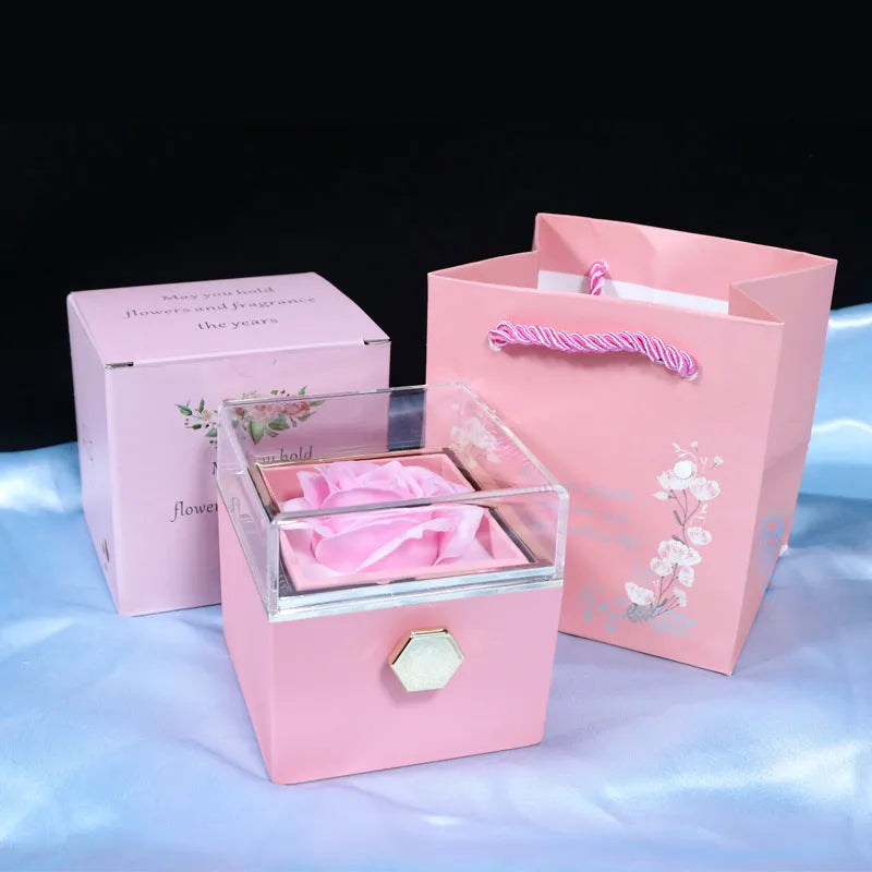 Rotating rose jewellery gift box with a preserved red rose under a clear acrylic dome, showing the interior rotating drawer.