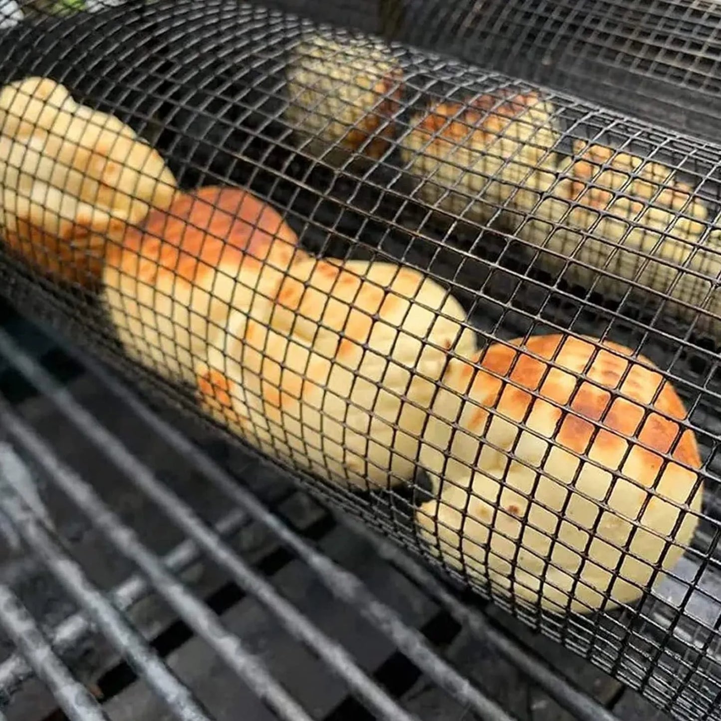 Silver iron wire rolling cylinder BBQ basket with mesh design and a hook for grilling.