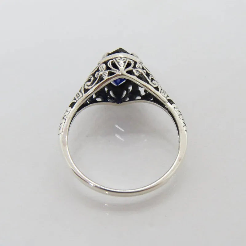 Silver women's ring with geometric hollow pattern and zircon detail on a finger.