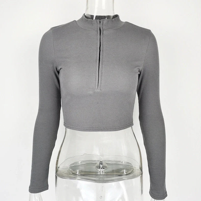 Women's black zip-front crop top with slim fit and long sleeves on hanger