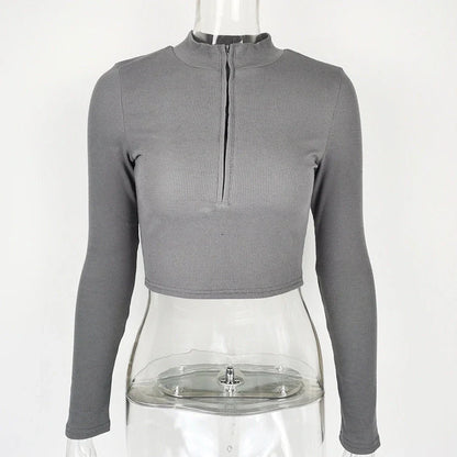 Women's black zip-front crop top with slim fit and long sleeves on hanger