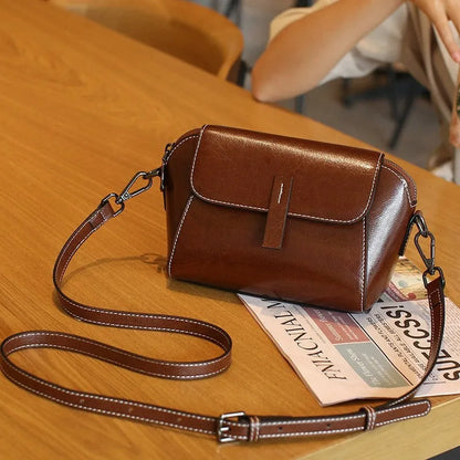Women's brown oil wax cowhide leather messenger bag with crossbody strap and organised interior pockets