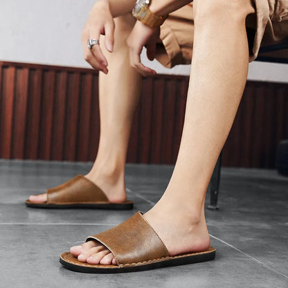 Brown leather men's sandals with a rubber sole on a neutral background