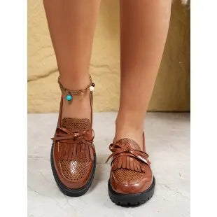 Women's brown artificial PU loafers with a bow detail on the pointed toe, shown on a size label.