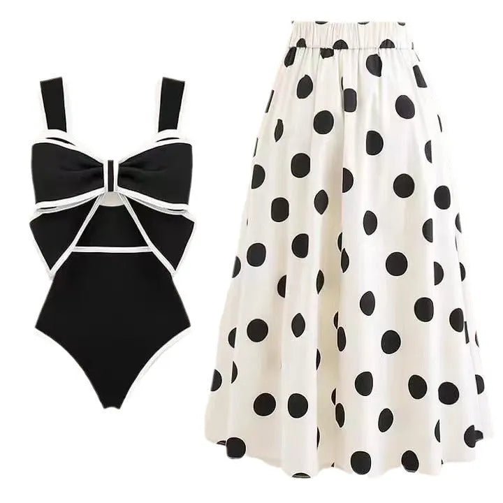 Women's black one-piece swimsuit with white attached round skirt and decorative bow at front