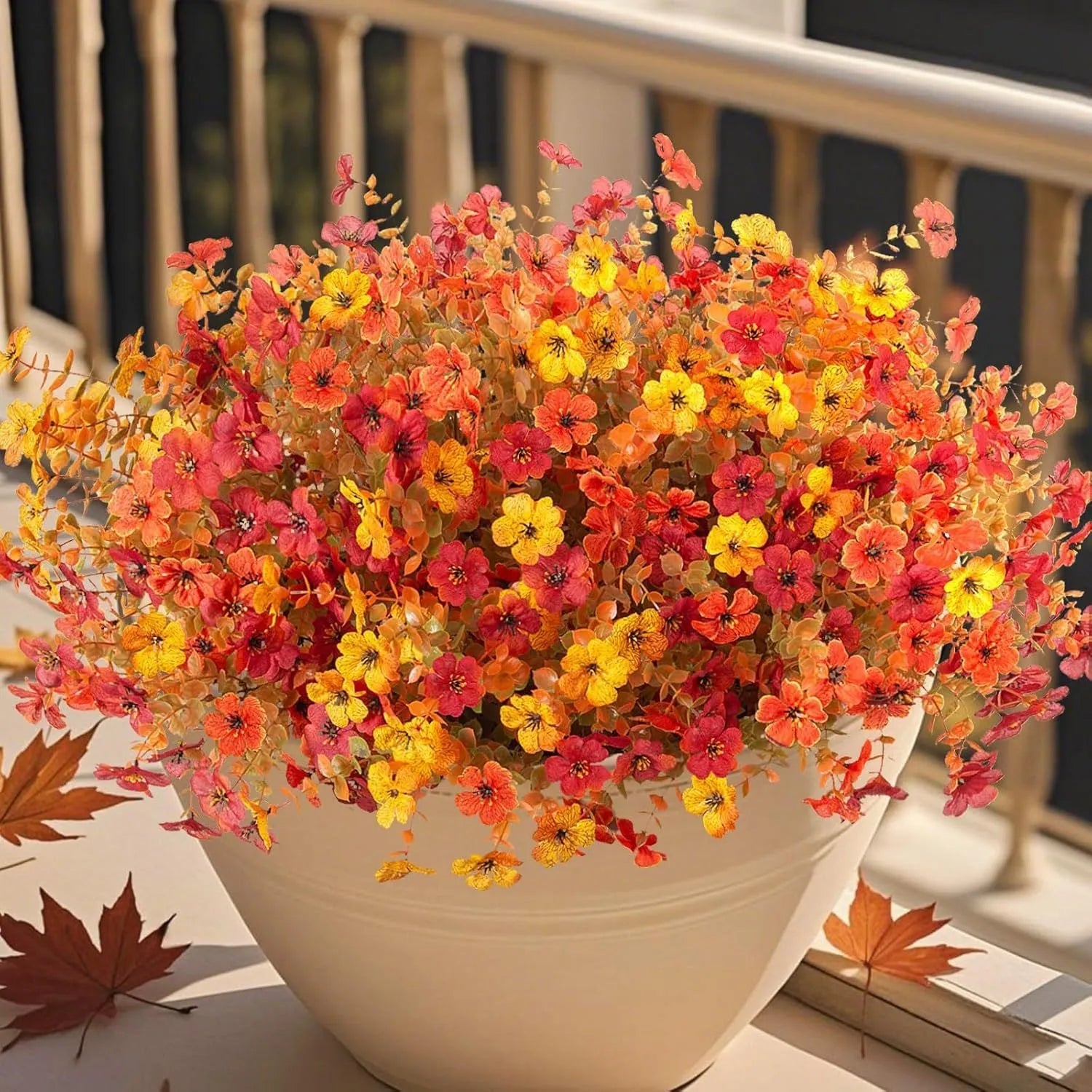 Artificial flower bouquet in autumn colours of red, yellow, and orange made from plastic and silk.