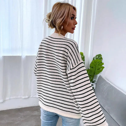 Black and white striped women's casual top with drop-shoulder sleeves and button detail