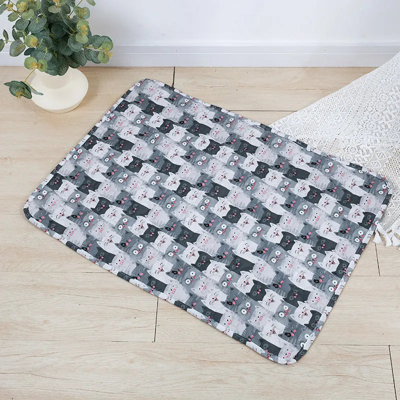 Reusable washable pet urine pad showing colourful animal pattern and waterproof backing.