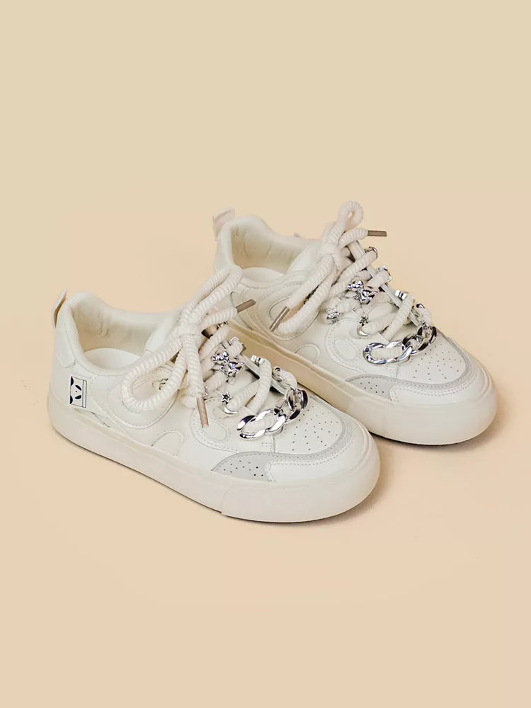 Women's white low-top sneakers with rubber sole and lace-up closure