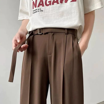 A pair of black straight leg wide fit women's trousers with a loose, casual silhouette on a hanger.