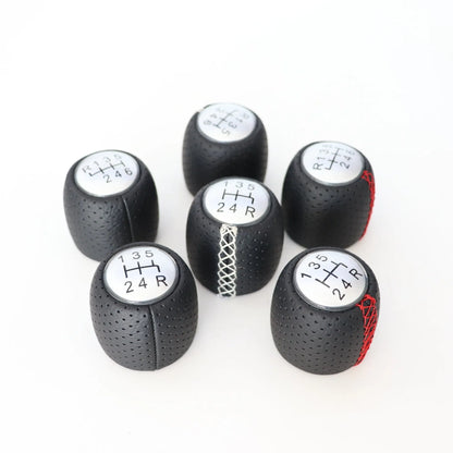 Sewn wrapped leather perforated style handball gear knob for Alpha vehicles in black, red, and white colour options.