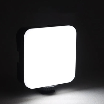 Square LED camera flash with universal hot shoe mount and rotatable head, shown with optional octopus stand tripod.