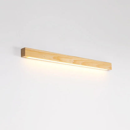 Slim walnut-coloured wooden strip wall lamp with acrylic light diffuser mounted on a plain wall.