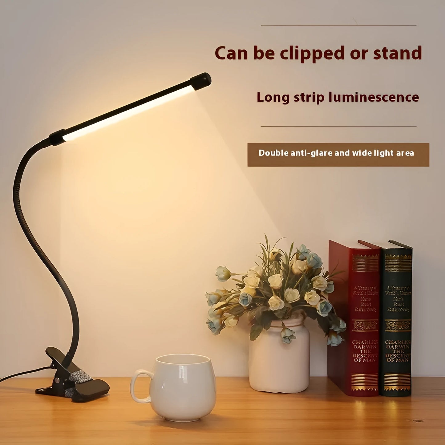 Black adjustable gooseneck desk lamp with USB cable bent over a notebook on a wooden desk.