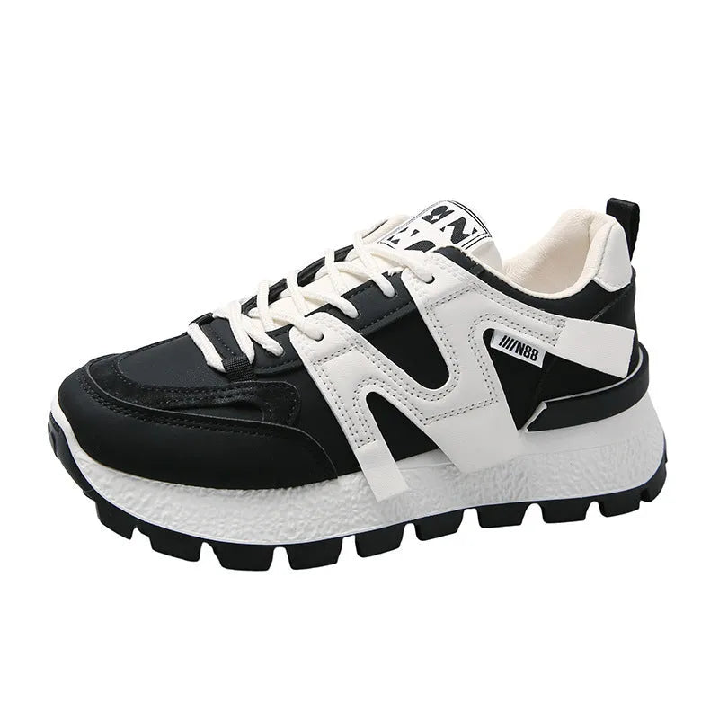 Low-top casual sneakers in black and white with rubber soles and lace-up front closure