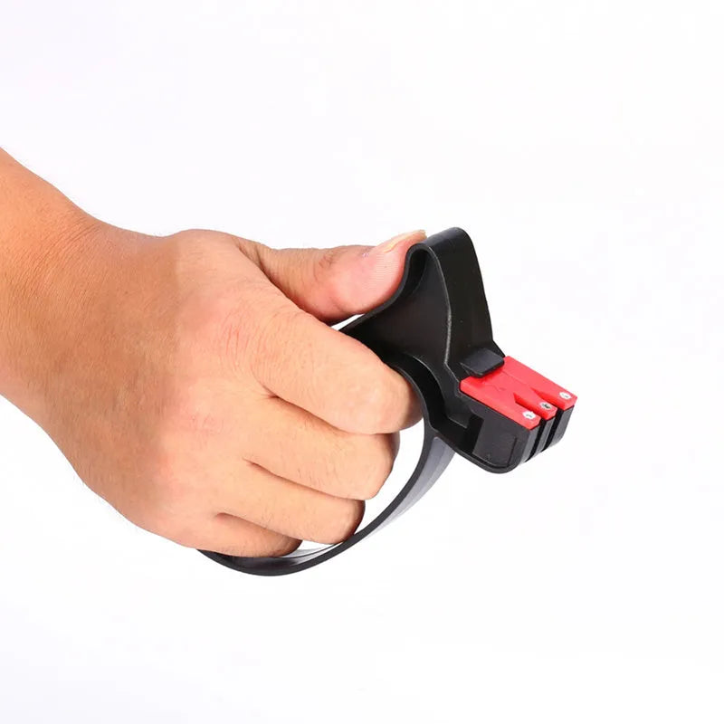 Black handheld knife and scissor sharpener with ergonomic grip, showing tungsten steel grindstone slot.