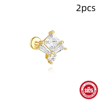 Close-up of a sterling silver double piercing chain stud earring with inlaid zircon stone in a golden colour.