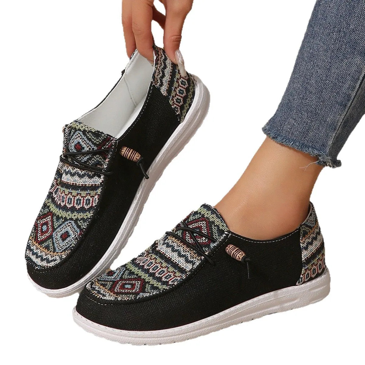 Women's black slip-on flat shoes with round toe and low-top design on a neutral background.