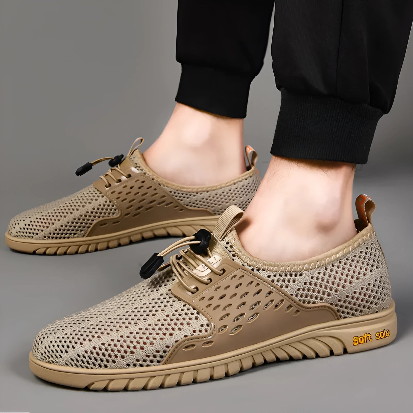 Men's black breathable mesh casual shoe with elastic band and rubber sole on a white background.