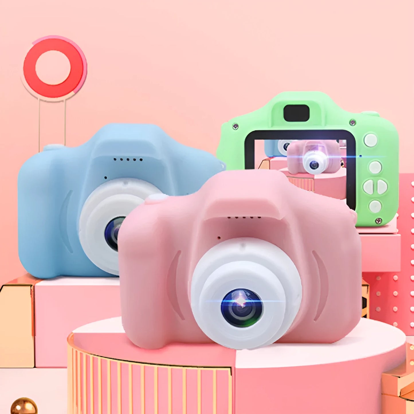 X2 HD mini digital camera for kids in silicone case with lanyard, shown capturing photo on 2-inch screen.