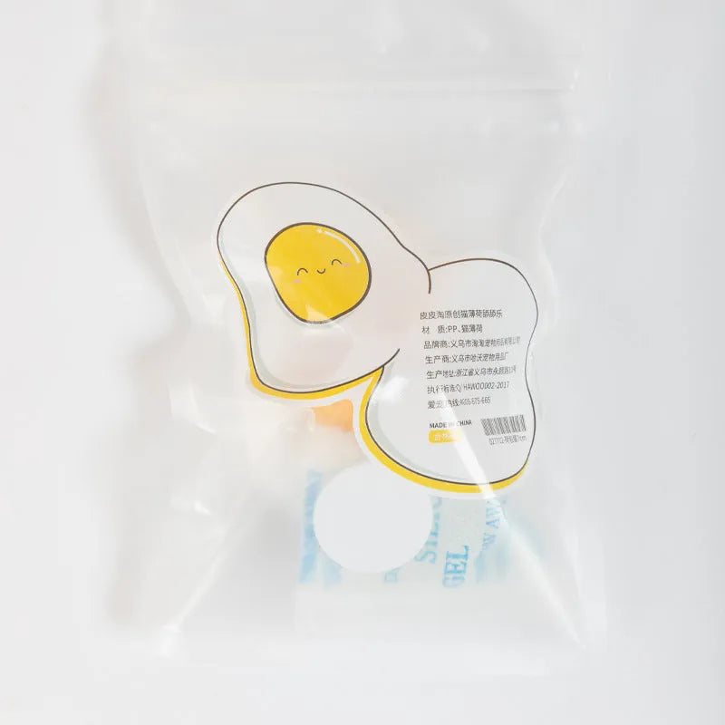 Fried egg shaped plush cat toy stuck to a window with a cat paw batting the 360-degree rotating ball.