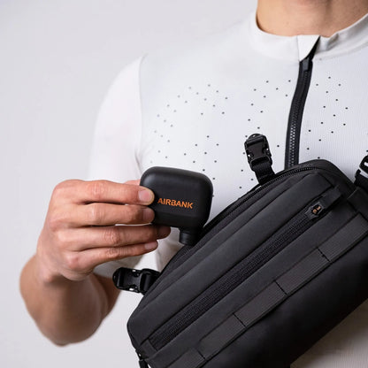 Black AS100 electric bicycle pump with digital display, USB charging port, and included waterproof bag