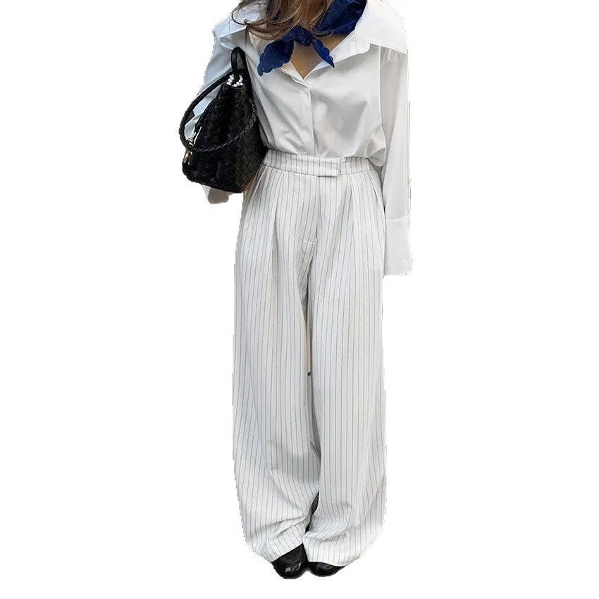 White women's wide-leg trousers with a striped pattern and zip detail, laid flat.