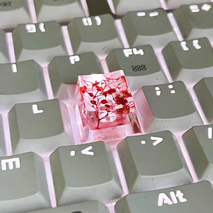Transparent resin mechanical keyboard keycap with glitter starry sky effect in red, pink, green, or violet.