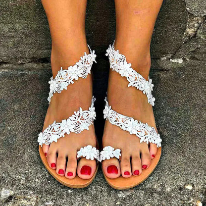 White plus size women's flat sandals with rhinestone and flower decorations on patent leather PU upper.