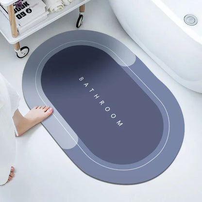 Oval diatomite bathroom floor mat in blue with natural rubber non-slip backing on tiled floor.