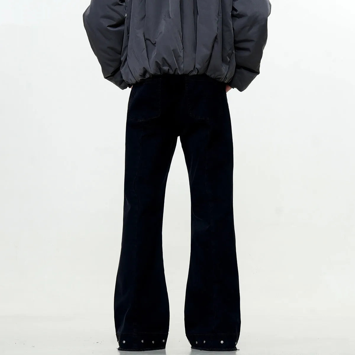 A pair of black straight-leg cotton jeans with a mid-waist fit and horn-style leg opening on a plain background.