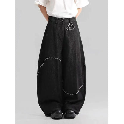 Men's black straight-leg denim trousers on a hanger, showing mid waist and zip fly detail.