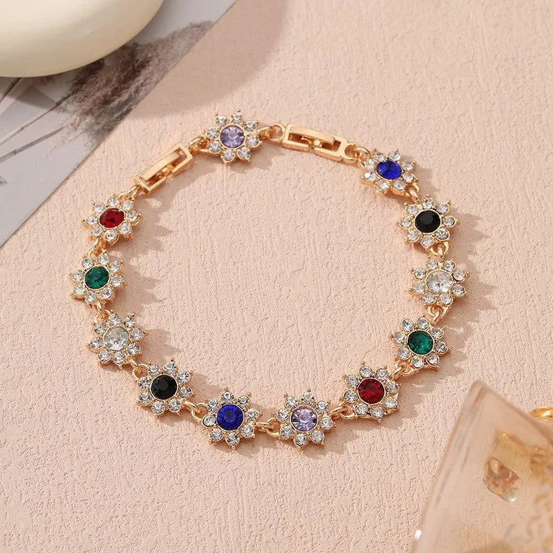 Gold and silver electroplated bracelets with flower charms set with coloured gemstones.