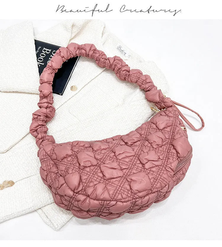 Women's light grey nylon underarm messenger bag with adjustable long strap, shown worn crossbody.
