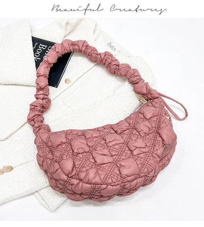 Women's light grey nylon underarm messenger bag with adjustable long strap, shown worn crossbody.