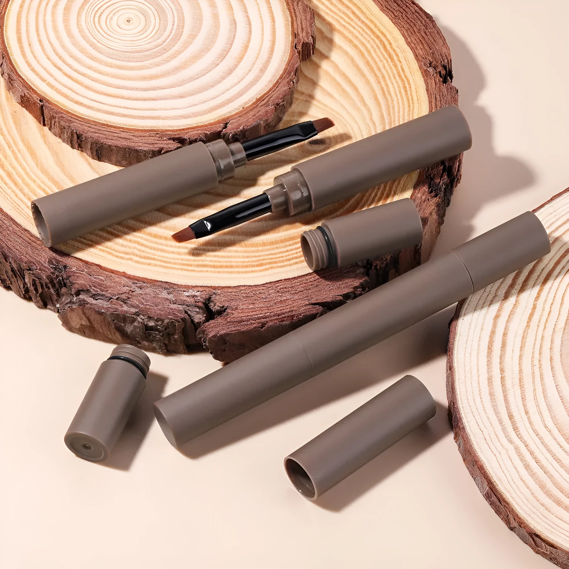 Double-headed eyebrow cream stick showing powder end and spoolie brush, with five colour shade options displayed.