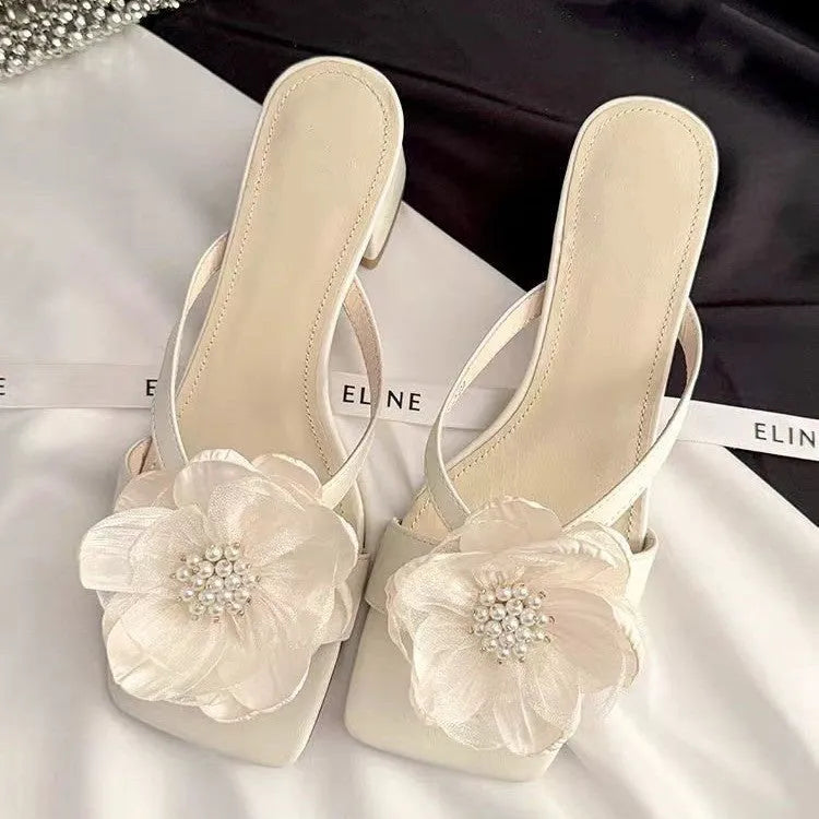Women's cream-white sandals with chunky heel, square toe, one-line strap, and a decorative flower on the satin upper.