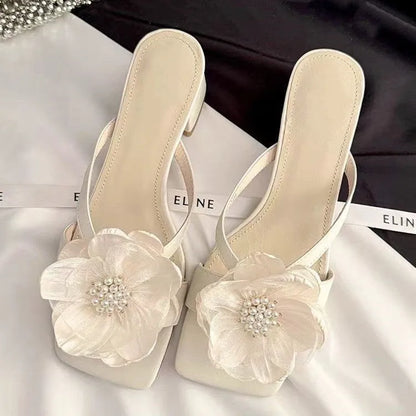 Women's cream-white sandals with chunky heel, square toe, one-line strap, and a decorative flower on the satin upper.