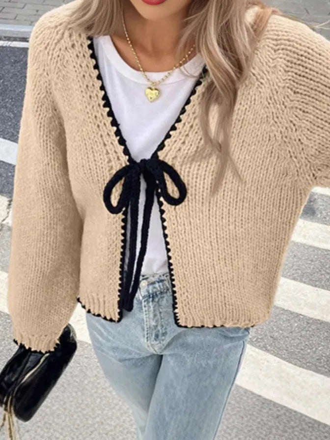 Grey lace-up front cardigan sweater with long sleeves and a crocheted flower detail.
