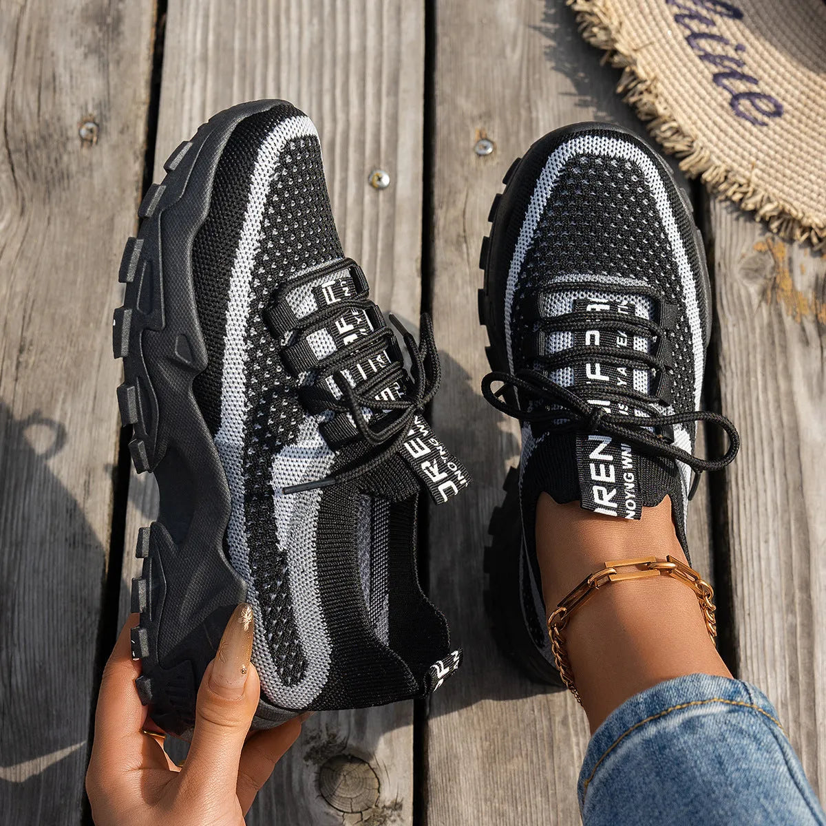 Women's Flyknit mesh lace-up sneaker in a grey colourway showing round toe and rubber sole.